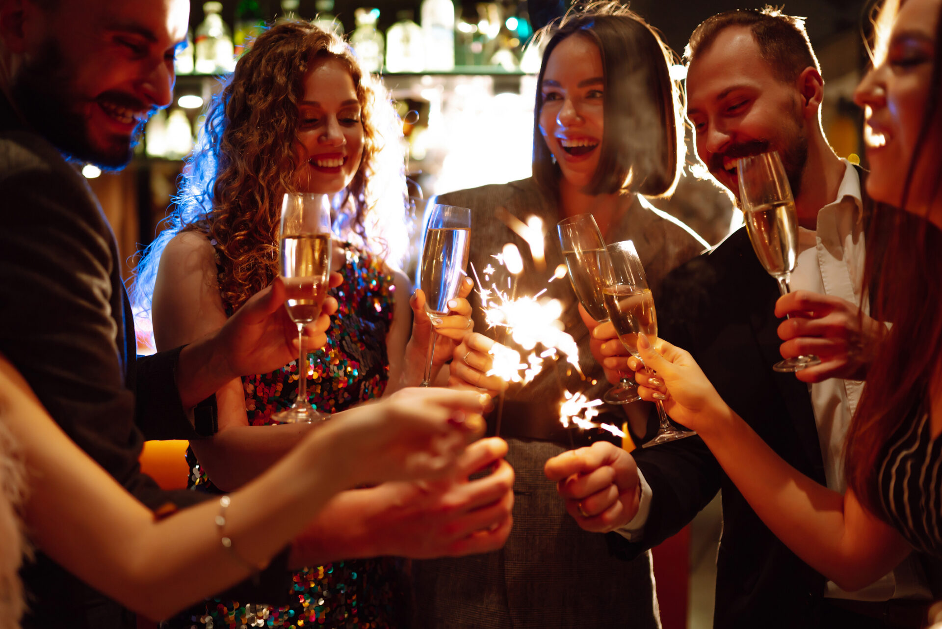 Friends celebrate Christmas or New Years party with sparklers and champagne.